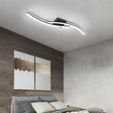 Modern ceiling light fixture in a bedroom with wooden wall and abstract art.